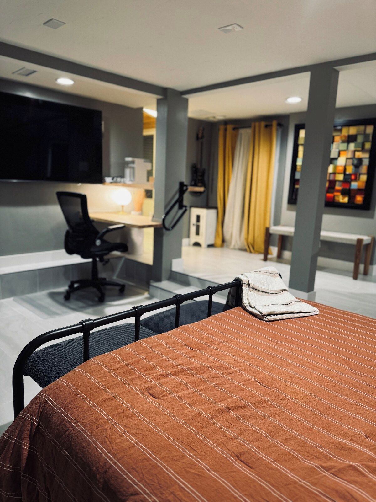 Quarto de hotel moderno com cama, escrivaninha e cadeira.