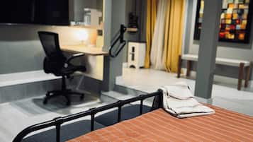 Quarto de hotel moderno com cama, escrivaninha e cadeira.