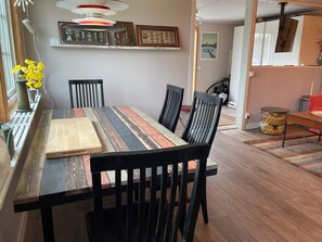Enjoy meals in this stylish dining area with a long table, black chairs, and colorful runner.