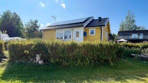A yellow house with a sloped roof and solar panels, surrounded by greenery. - 4 Star Holiday Home in Vingaker (Vingåker)
