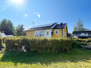 A yellow house with a sloped roof and solar panels, surrounded by greenery. - 4 Star Holiday Home in Vingaker (Vingåker)