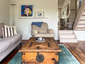 A living room with a sofa, a coffee table, a chest, and a staircase. - 4 Star Holiday Home in Vaxholm (Vaxholm)