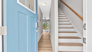 A hallway with a blue door, wooden stairs, and a ceiling fan. - Ducks Landing Accommodations at Southern Pines Golf Course (Aberdeen)