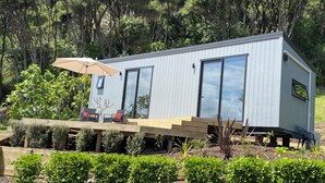 Una casa moderna amb una terrassa, mobiliari exterior i un gran finestral.