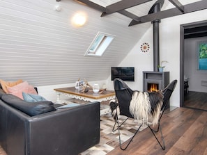 A modern living room with a sofa, a coffee table, a fireplace, and a television. - 4 Person Holiday Home in Toftlund (Toftlund)
