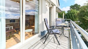 A balcony with outdoor seating, a view of the interior, and a railing. - Residence Johannsens B 12 - Residence Johannsens (Timmendorfer Strand)
