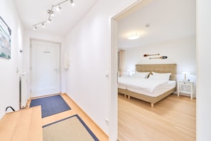 Un dormitorio moderno con cama, mesitas de noche y cabecero.