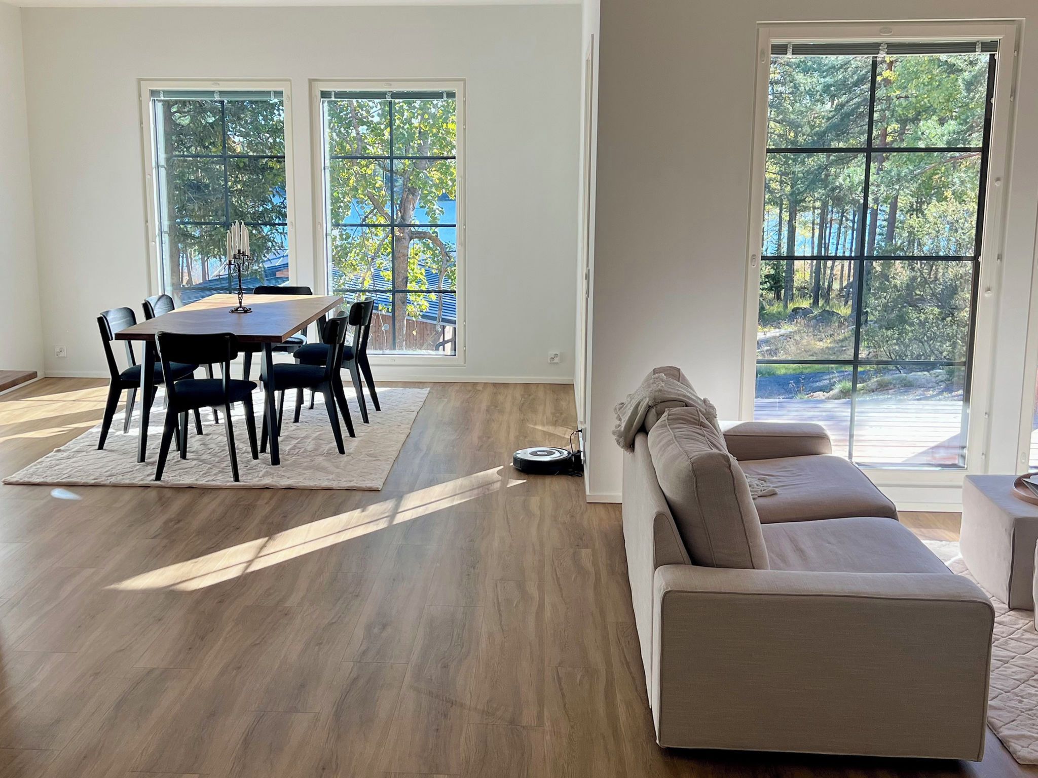A spacious living room with a dining area, large windows, and a modern design.