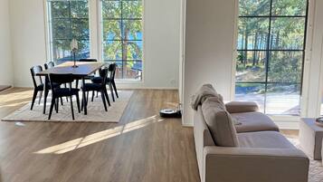 A spacious living room with a dining area, large windows, and a modern design.