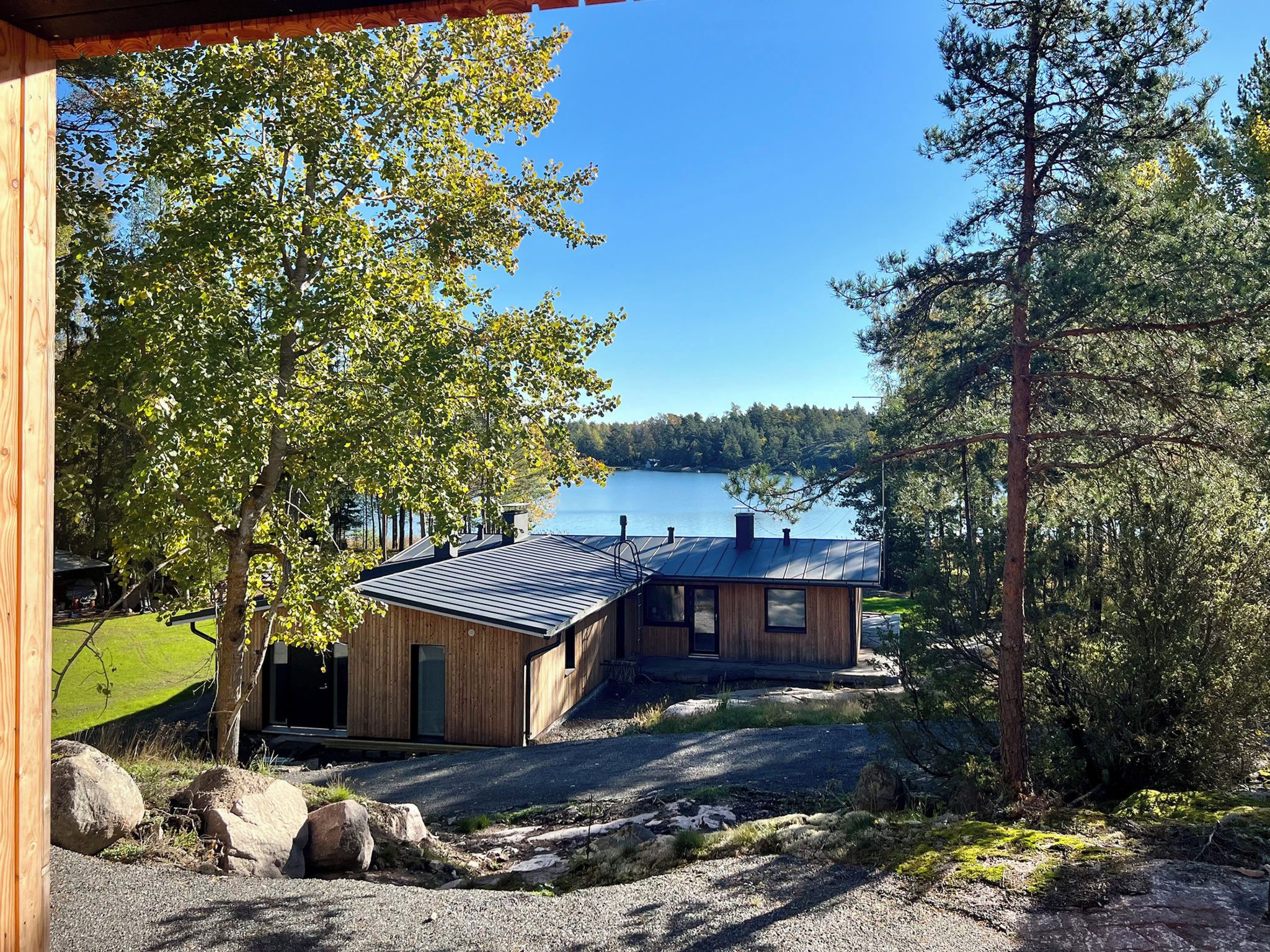 A cabin with a metal roof, wooden walls, and a view of a lake.
