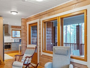 L’intérieur d’une cabane comprend une cuisine, un coin repas et un balcon avec vue sur les arbres.