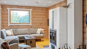 Una sala de estar acogedora con detalles de madera, un sofá, una mesita de centro y una chimenea.