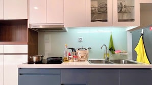 A modern kitchen with a sink, stove, and cabinets. - G3- Green Bay (Hanoi)