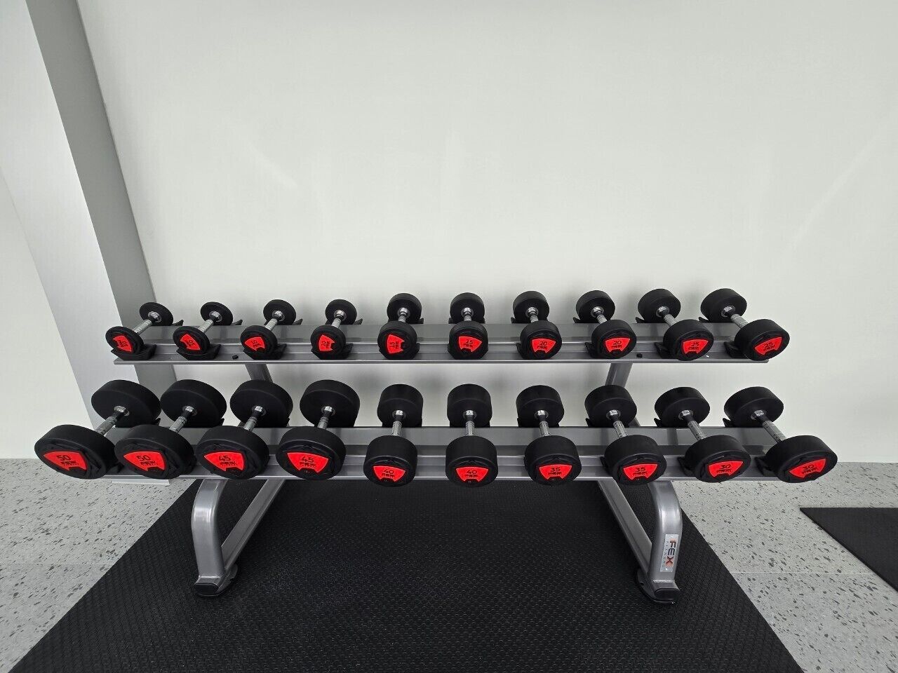 A set of adjustable dumbbells on a rack.