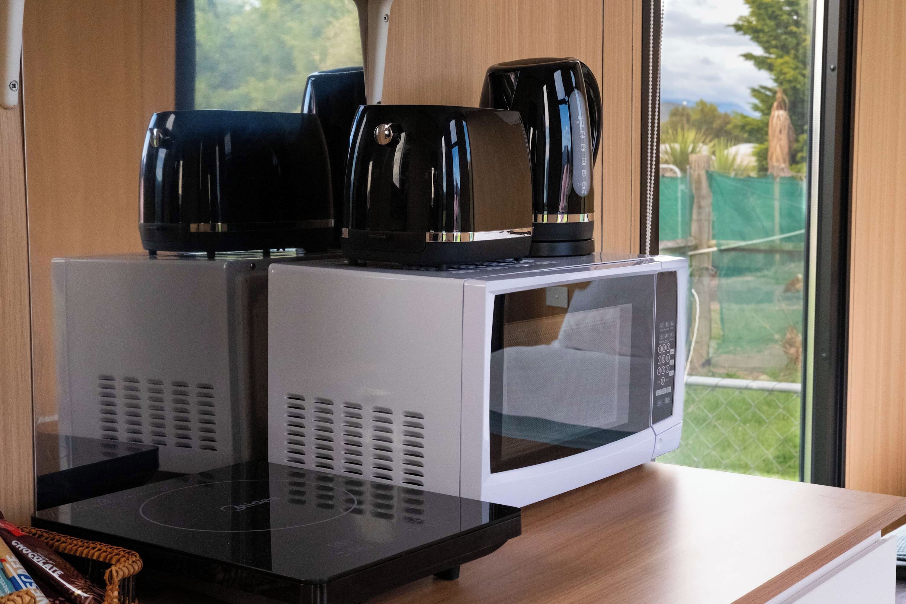 A kitchen area with a microwave and a coffee maker on a countertop.