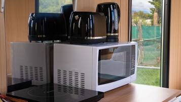 A kitchen area with a microwave and a coffee maker on a countertop.