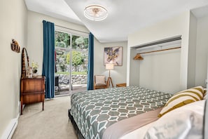 A bedroom with a large bed, a desk, a chair, a window with curtains, and a ceiling fan. - Cozy Home with Ocean and Mountain views. Family sized wth game room and deck (Gibsons)