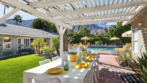 A covered outdoor dining area with a pool and mountains in the background. - Villa Sol: Private Las Palmas Estate Home (Palm Springs)