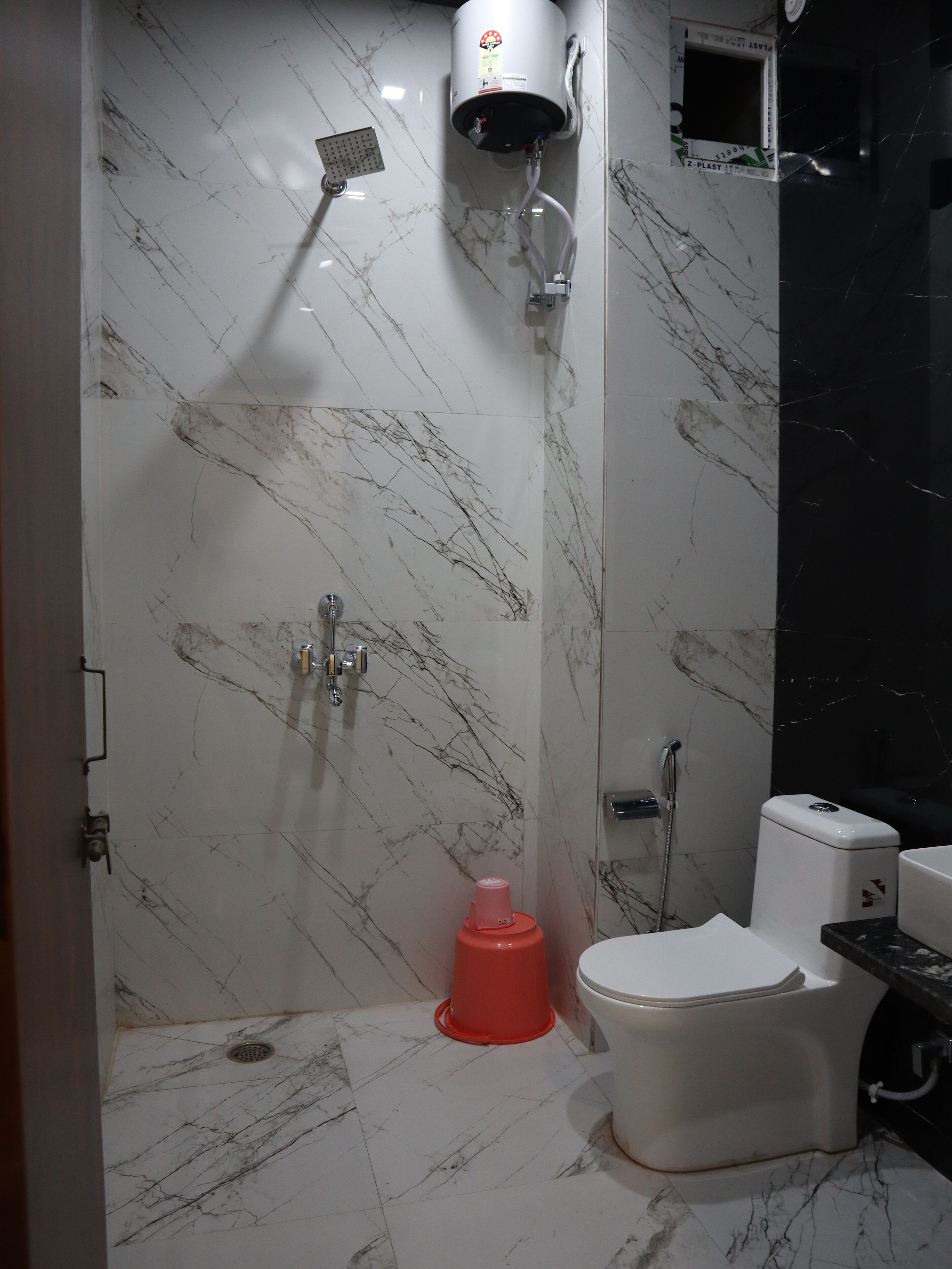 A bathroom with a white toilet, a shower, and a sink.