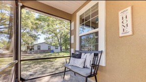 A covered porch with a bench, a view of a house, and a 'Welcome to Your Home' sign. - Spacious 3BR Two-Story Home Near Downtown Jax (Jacksonville)