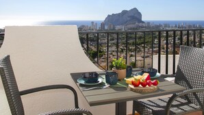A balcony with a table set for breakfast, overlooking a cityscape and the sea. - Imperial Park by Interhome (Calpe/Calp)