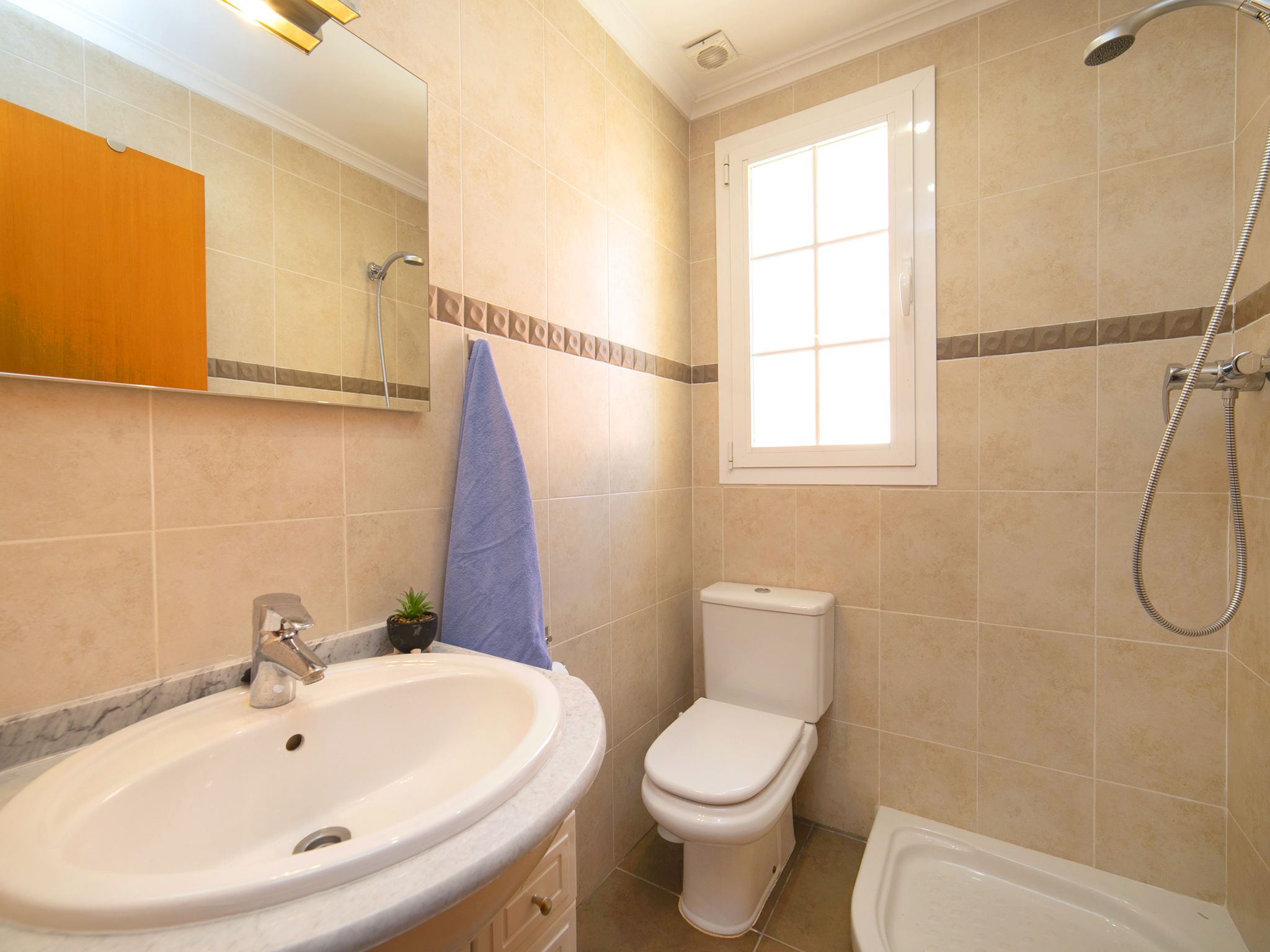 A bathroom with a sink, toilet, and shower.