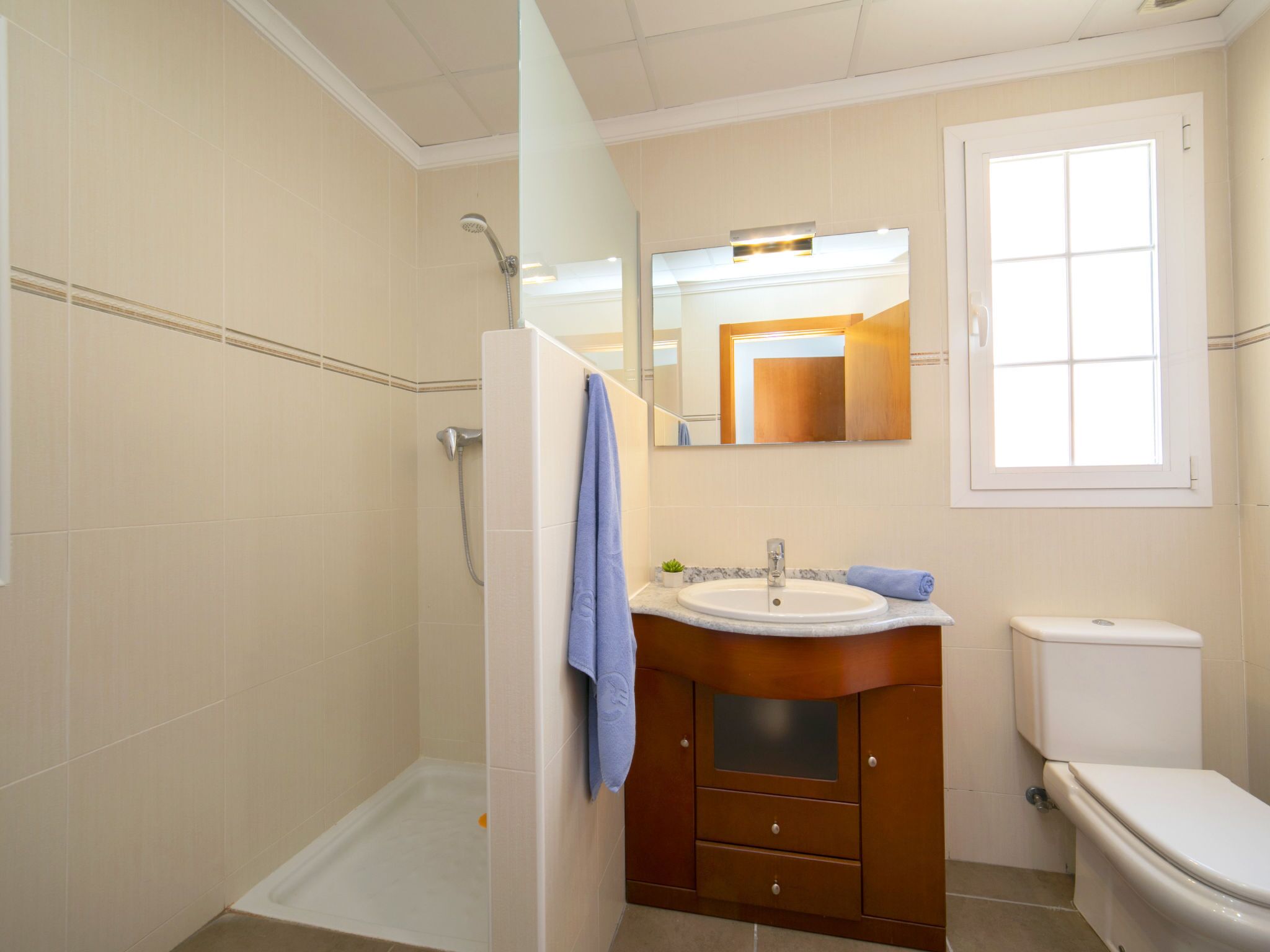 A bathroom with a shower, sink, and toilet.