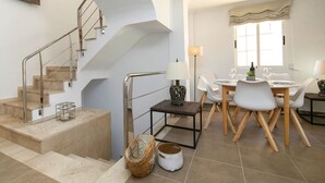 Ein modernes Interieur mit Treppe, Essbereich und einem fensterbepflanzten Fenster.