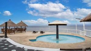A pool area with lounge chairs and umbrellas, overlooking the sea. - Costa de Leticia (Alegria)