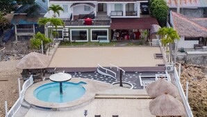 A resort with a swimming pool, lounge chairs, and a covered deck area. - Costa de Leticia (Alegria)