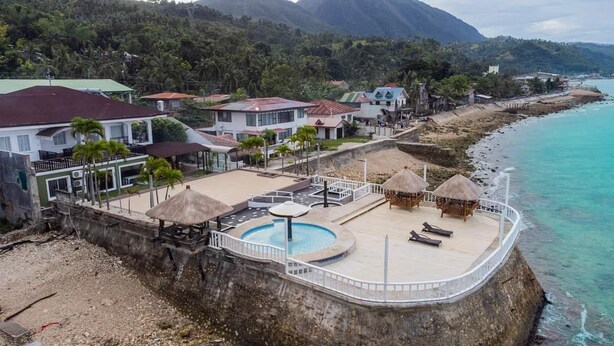A coastal property with a swimming pool, beach umbrellas, and a view of the ocean. - Costa de Leticia (Alegria)