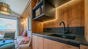 Eine moderne Küche mit Holzschränken, einer schwarzen Arbeitsplatte und einem Edelstahl-Spülbecken.