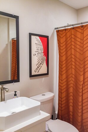 A bathroom with a white sink, toilet, and a shower curtain. - Modern SD Escape: SDSU/Downtown <10 Min, GameRoom, Fire Pit, Easy Freeway Access (La Mesa)
