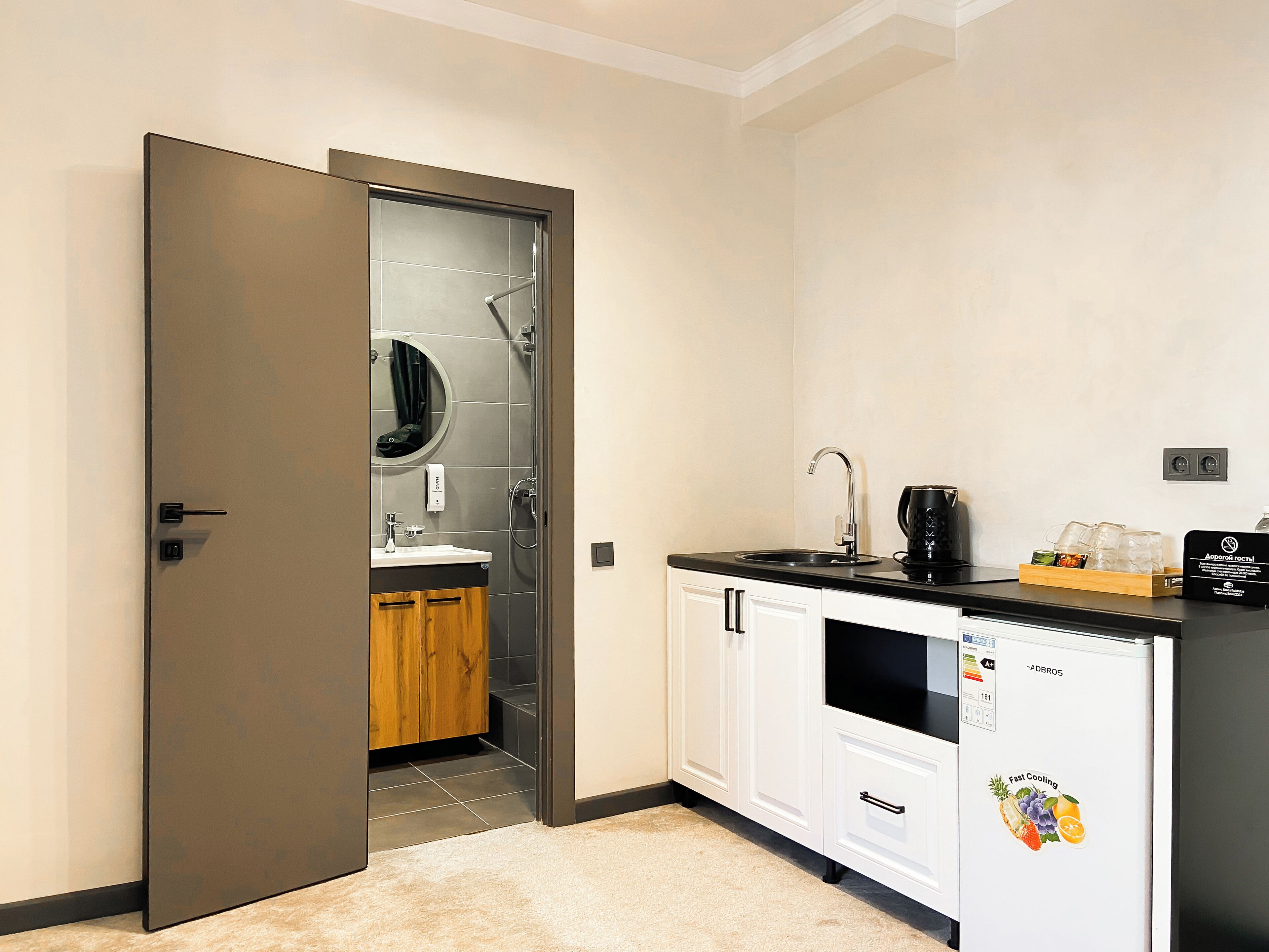 A modern kitchen with a sink, coffee maker, and refrigerator.