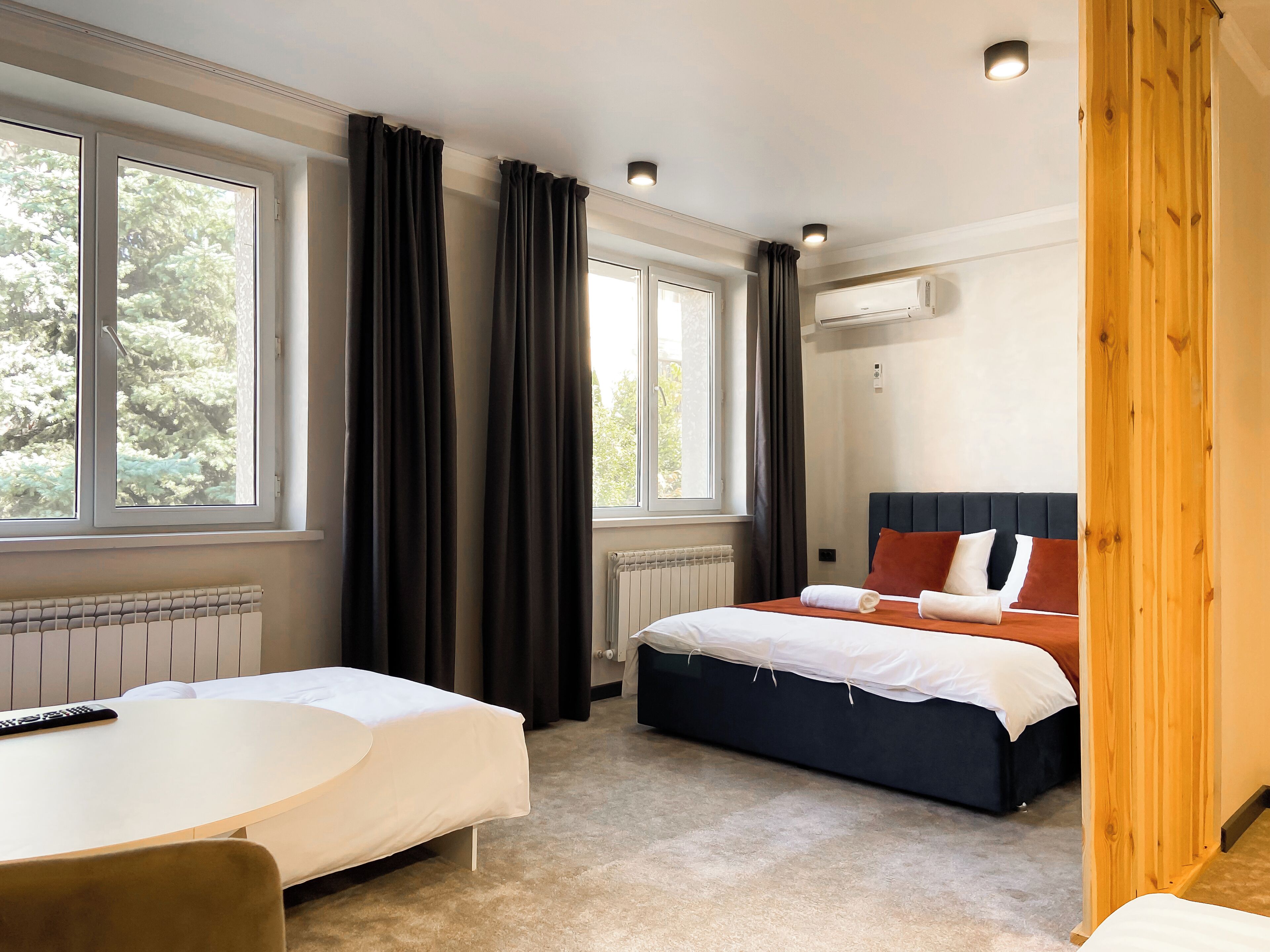 Una habitación de hotel con dos camas, un escritorio y una ventana con cortinas.