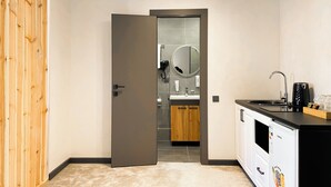 A modern kitchen with a built-in dishwasher, a sink, and a coffee maker. - Beles Apartments (Almaty)