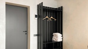 A room with a dark-colored wardrobe, a door, and a bed. - Beles Apartments (Almaty)