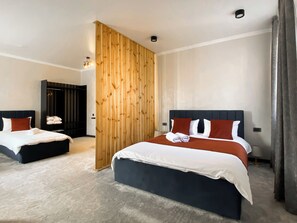 A hotel room with two beds, a wooden partition, and a wardrobe. - Beles Apartments (Almaty)