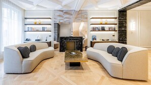 A modern living room with two sofas, a central coffee table, and built-in shelving with decorative items. - Hôtel  Particulier#Monceau#5 Chambres #Grand luxe (Paris)