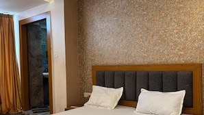 Une chambre moderne avec un grand lit, une tête de lit en bois et un ventilateur de plafond.