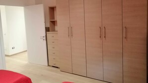 Een kamer met een grote kast, een klein bureau en een stoel.