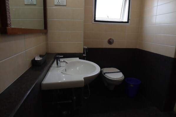 Un bagno con lavandino, wc e una finestra.