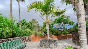 A stone pathway leading to a bench, surrounded by lush greenery and palm trees. - Parque Don Jose Vista Teide by Interhome (Costa del Silencio)