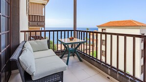 A balcony with a sofa and a small table, overlooking a coastal view. - Balcón del Mar by Interhome (Costa del Silencio)