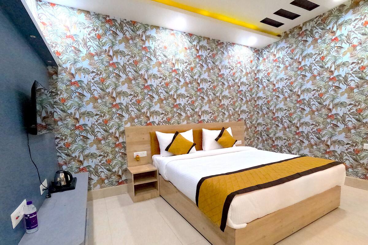 A bedroom with a bed, bedside tables, a TV, and a water bottle.
