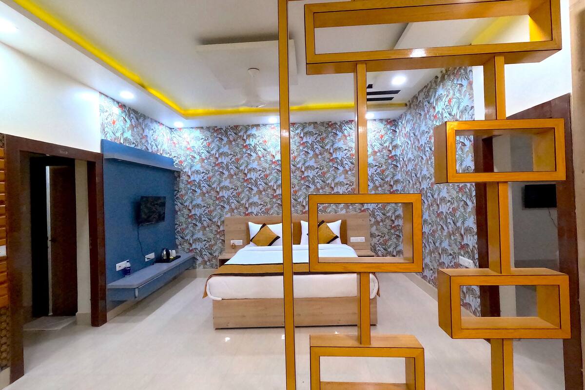 A bedroom with a bed, a blue wall unit, and a decorative wooden partition.