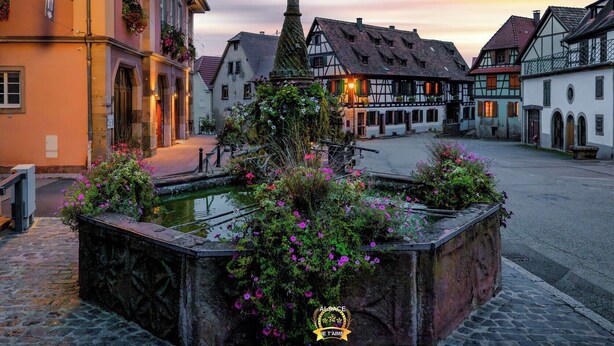 A courtyard with a fountain, surrounded by traditional European architecture.