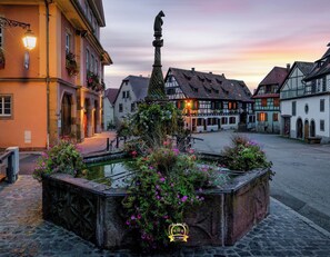 Un patio con una fuente, rodeado de arquitectura europea tradicional.