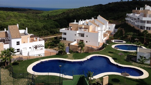 A residential area with modern white buildings, a swimming pool, and a view of the sea. - Magnificent apartment. in luxury complex - swimming pools (AN)