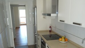 A modern kitchen with white cabinets, stainless steel appliances, and a beige countertop. - Magnificent apartment. in luxury complex - swimming pools (AN)